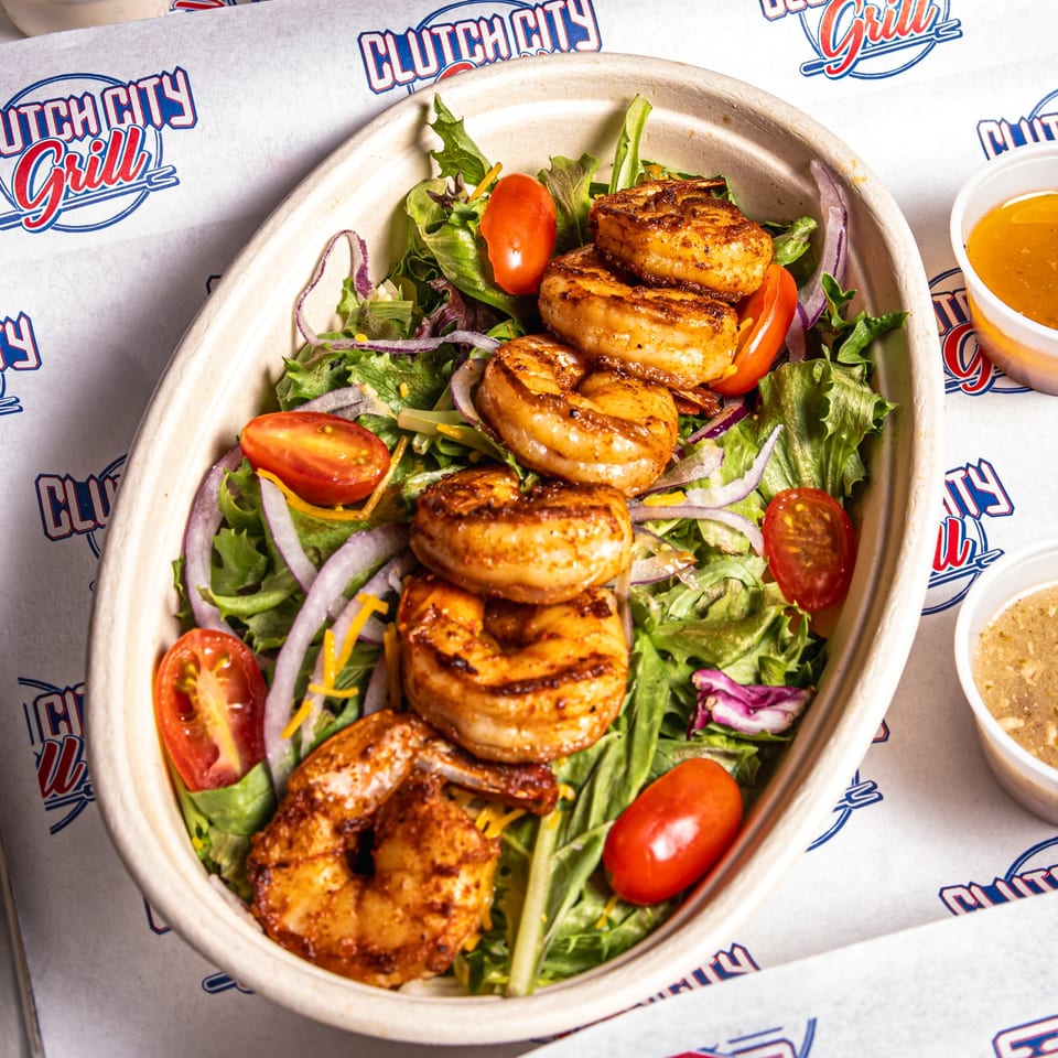 Clutch City Grill's grilled shrimp salad with lettuce, tomatoes, red onions, and dressing.